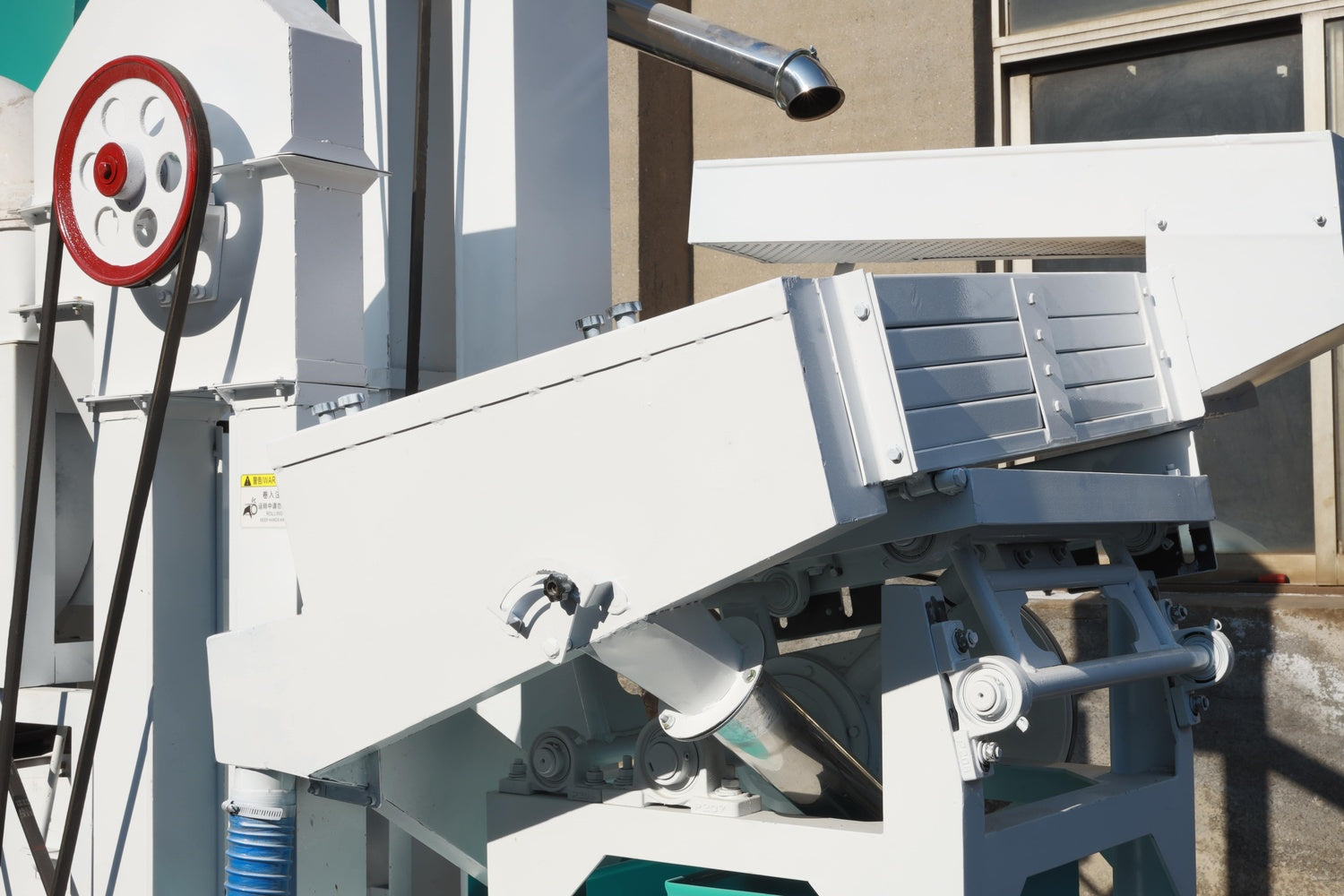 Industrial machine or equipment with various components on a building exterior.