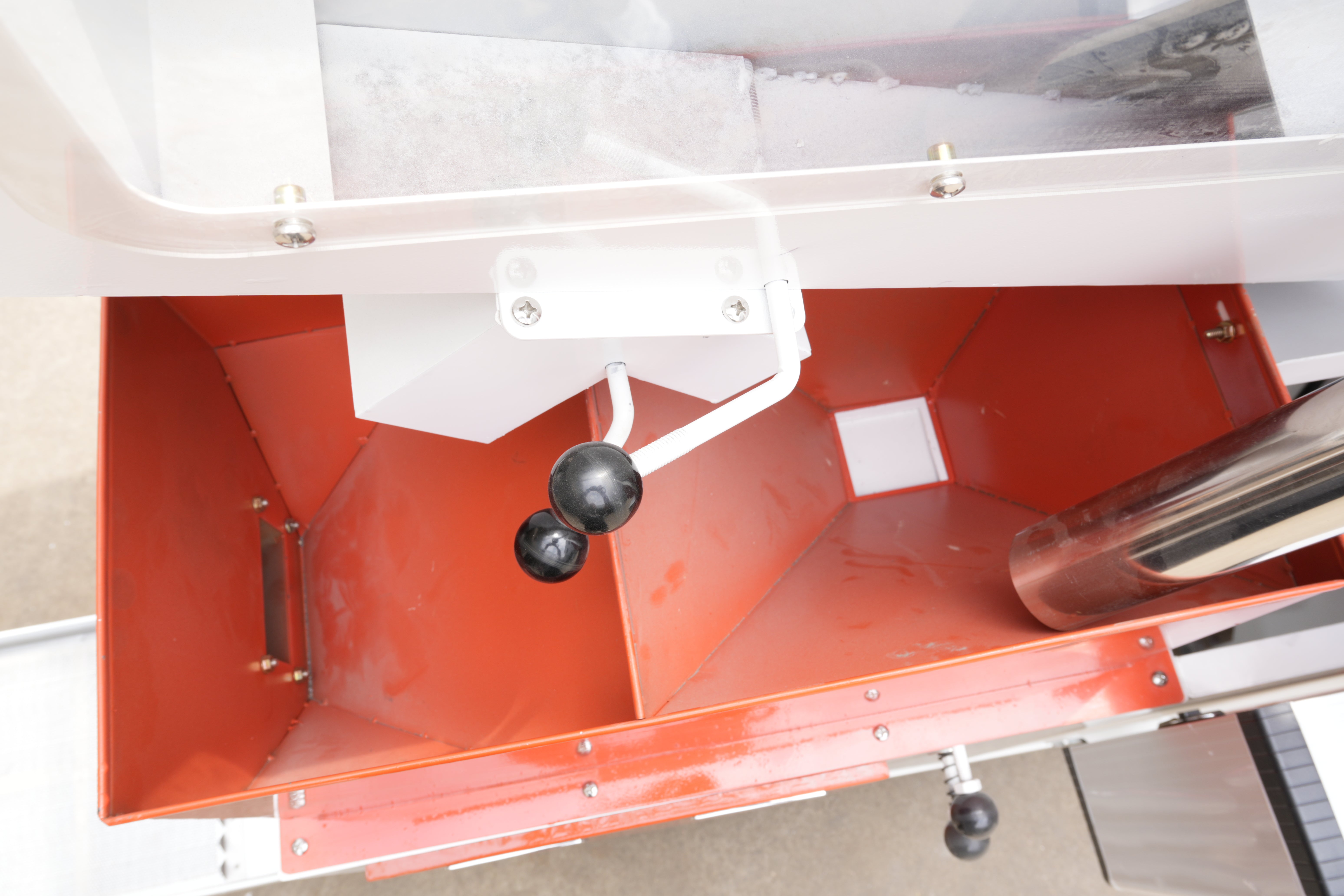 Close-up of a red metal cabinet with a white frame, showing visible wear and rust.