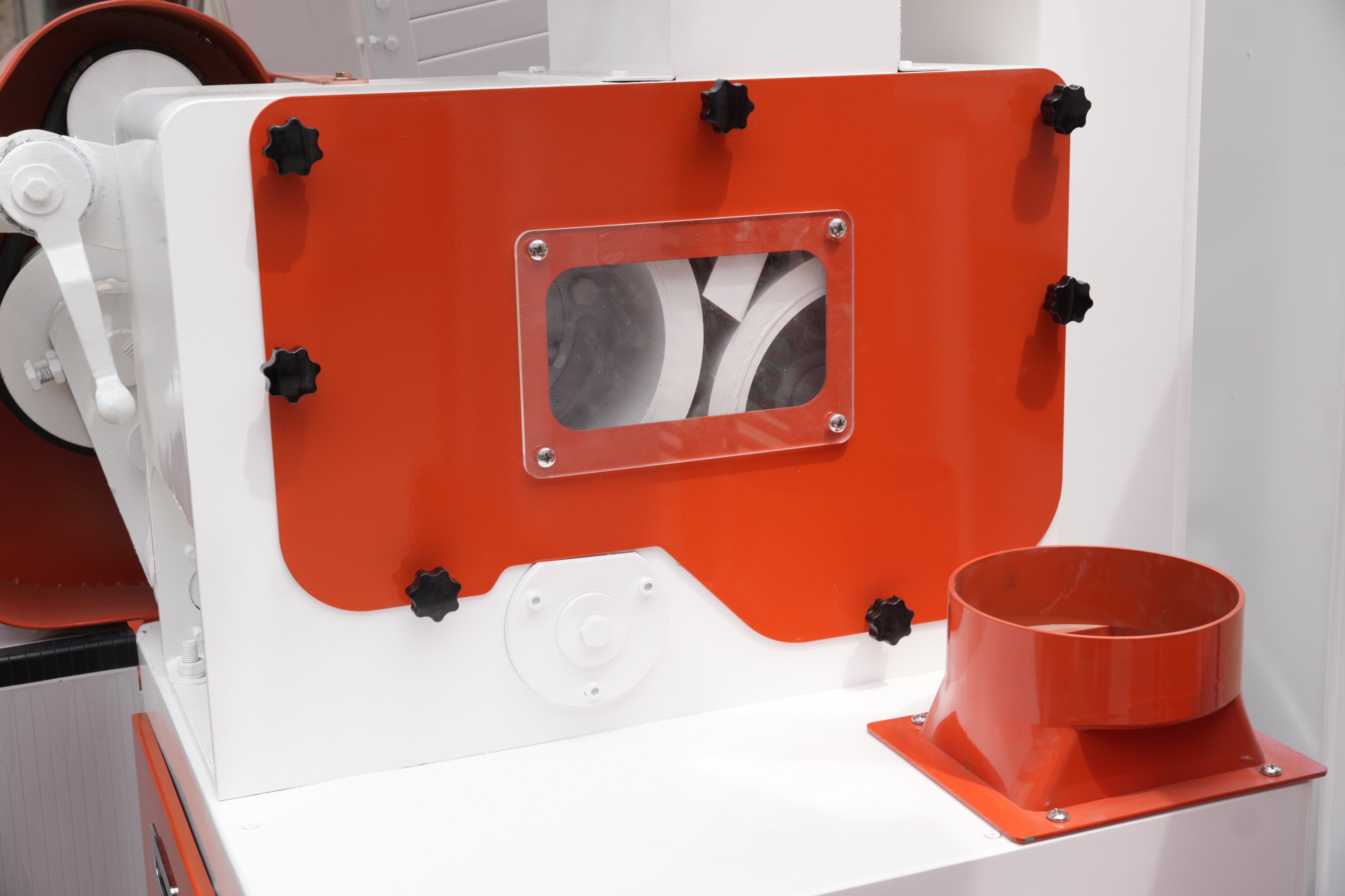 Red and white machine with a fan and cylindrical component on a white background